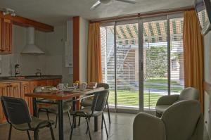 a kitchen with a table and chairs and a large window at Nuna Ayni Apartments in Alta Gracia