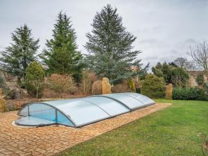 un invernadero en un jardín con árboles en el fondo en Modern holiday home with shared swimming pool in Mittelndorf, en Mittelndorf