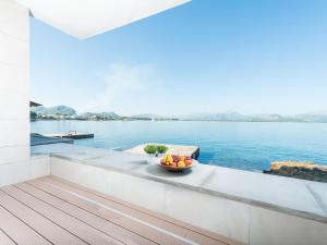 a bowl of fruit sits on the edge of a balcony overlooking the water at Aixa - House In Marina Manresa Free Wifi in Alcudia