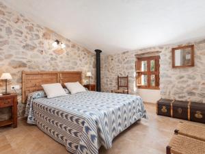 - une chambre avec un lit dans une pièce dotée de murs en pierre dans l'établissement Cal Tio - House In Caimari Free Wifi, à Caimari