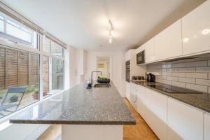 a kitchen with white cabinets and a counter top at Charming spacious 2-Bed Apartment in London in London