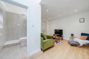 a living room with a green couch and a bathroom at Charming spacious 2-Bed Apartment in London in London