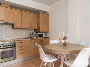 cocina con mesa de madera y sillas blancas en Bonanza 5 - Apartment In Colònia De Sant Jordi Free Wifi en Colonia Sant Jordi