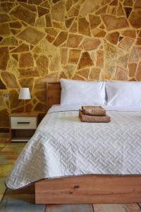 a bedroom with a bed with a stone wall at Κρητικό παραδοσιακό διαμέρισμα! in Chania Town