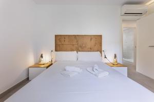 een slaapkamer met een groot wit bed en 2 handdoeken bij Can Perello in Muro