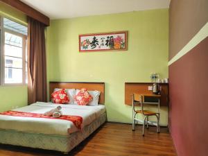 Un dormitorio con una cama con un osito de peluche. en OYO 90964 Melody 88 Inn, en Miri