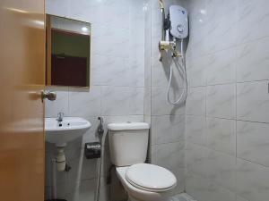 y baño con aseo y lavamanos. en OYO 90964 Melody 88 Inn, en Miri