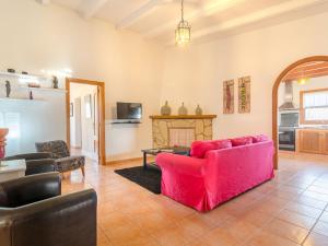 ein Wohnzimmer mit einem roten Sofa und einem Kamin in der Unterkunft Barranc De Son FullÓs - Villa With Private Pool In Santa Margalida Free Wifi in Santa Margalida