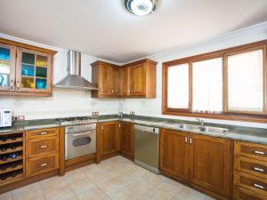 a kitchen with wooden cabinets and a stove top oven at Cas Barber - Villa With Private Pool In Muro Free Wifi in San Lorenzo