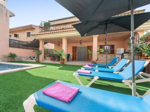 a group of lounge chairs and an umbrella in a yard at Cas Barber - Villa With Private Pool In Muro in San Lorenzo