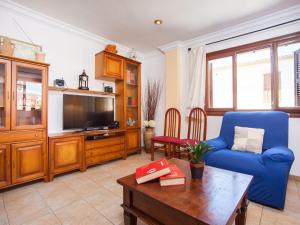 a living room with a blue couch and a tv at Cas Barber - Villa With Private Pool In Muro Free Wifi in San Lorenzo