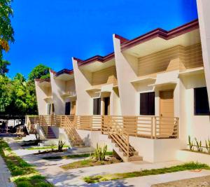 曼巴豪Rose Inn的一座大型白色建筑,设有木制阳台