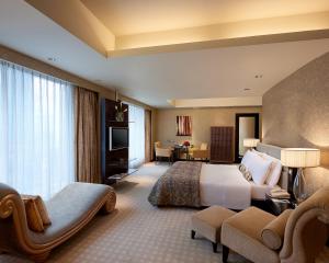 duży pokój hotelowy z łóżkiem i kanapą w obiekcie Cinnamon Grand Colombo w Kolombo