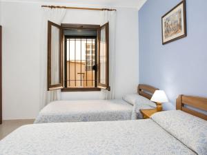- 2 lits dans une chambre avec fenêtre dans l'établissement Beautiful Holiday Home in Esclanya with Swimming Pool, à Brugarol