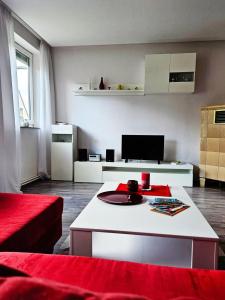 sala de estar con sofá rojo y mesa blanca en NEU! Ferienhaus zur Hortensie, 