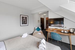 a bedroom with a bed and a desk with a television at Hotel George Vienna in Vienna