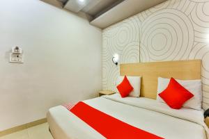 a hotel room with a bed with red pillows at OYO Happy Inn in New Delhi