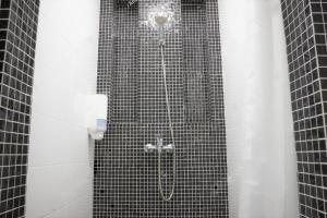 y baño con ducha y azulejos negros. en Benedettini - Suites, en Catania 110 fotos más