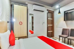 a bedroom with a bed and a tv and chairs at OYO Happy Inn in New Delhi