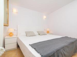 Cama blanca en habitación blanca con 2 lámparas en Ses Canyes - Apartment With Private Pool In Muro, en Playa de Muro