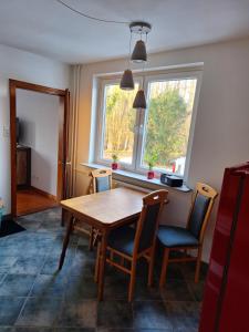 a dining room with a table and chairs and a window at Nebenan in Soltau