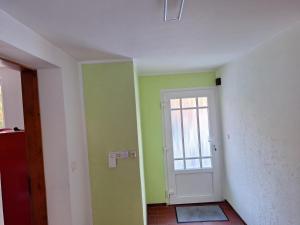 a room with green and white walls and a door at Nebenan in Soltau