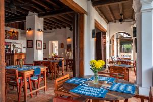 un restaurant avec des tables et des chaises en bois bleu et blanc dans l'établissement Residence Bassac, à Champassak