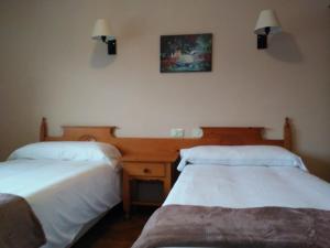 1 dormitorio con 2 camas, escritorio y una foto en la pared en San telmo, en Tui