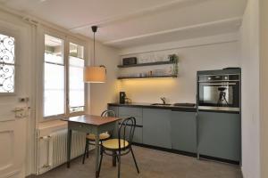 eine Küche mit einem Tisch und einer Arbeitsplatte in der Unterkunft Union Apartments Bern-Belp in Belp