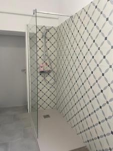 een douche in een badkamer met een tegelwand bij B&B rue Royale Versailles in Versailles