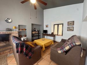 een woonkamer met 2 banken en een tafel bij Casa rural en Badajoz in Jerez de los Caballeros