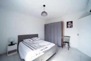 Un pat sau paturi într-o cameră la L'impertinente - Maison climatisée avec jacuzzi