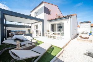 une arrière-cour avec une terrasse dotée de chaises et d'une table dans l'établissement L'impertinente - Maison climatisée avec jacuzzi, à Pia