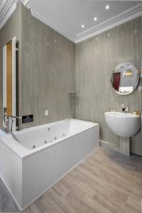 uma casa de banho com uma banheira e um lavatório e uma banheira em Breck Apartments em Poulton le Fylde