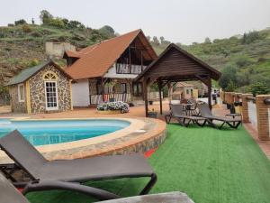 a house with a pool and chairs and a house at Casa Oasis in Torrox