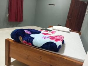 a bed with a blue and white blanket on it at ALPHA Hotel in Imphal