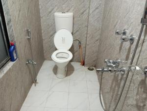 a bathroom with a toilet in a shower stall at ALPHA Hotel in Imphal