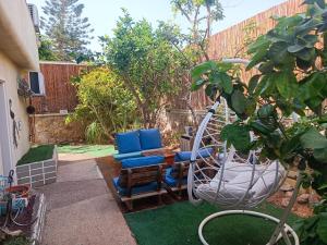 a patio with a swing and a chair at Red Sea Garden Apartment in Eilat