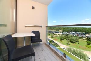 un bureau avec un bureau, des chaises et une grande fenêtre dans l'établissement Hotel Materada Plava Laguna, à Poreč