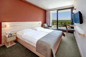 a hotel room with a bed and a large window at Hotel Materada Plava Laguna in Poreč