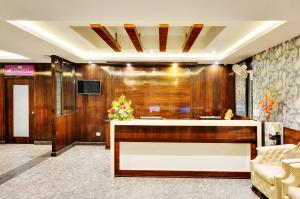 a lobby with a reception desk in a building at Inaara Hotel, Bangalore in Bangalore