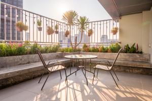a patio with a table and chairs on a balcony at The Victory View in Bangkok