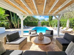 a patio with couches and a table and a pool at Spacious Retreat with Games in Benissa