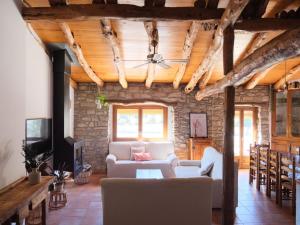 Modern Mansion in Guimera with Private Pool في Guimerá: غرفة معيشة مع أريكة بيضاء وجدار حجري