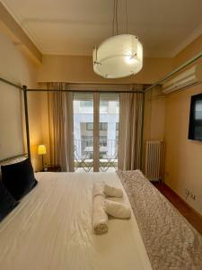 1 dormitorio con 1 cama blanca grande y toallas. en Athens Spirit Apartment en Athens