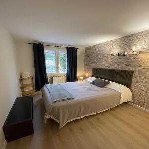 a bedroom with a large bed and a brick wall at villa provençale in Pierrevert