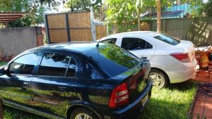 a blue car parked next to a white car at El Portal in Posadas