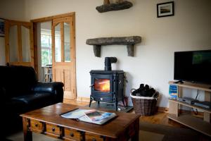 uma sala de estar com um fogão a lenha em *Spacious Irish Cottage* em Fanore