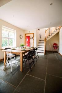 uma sala de jantar com uma mesa e cadeiras e uma escadaria em *Spacious Irish Cottage* em Fanore