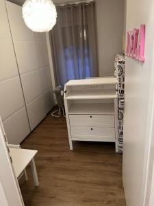 Habitación pequeña con escritorio blanco y espejo. en Appartement Cormondrèche, en Neuchâtel